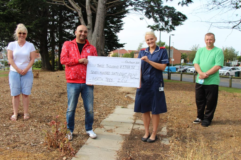 Members of the pool club. One holds a giant cheque with a member of staff.