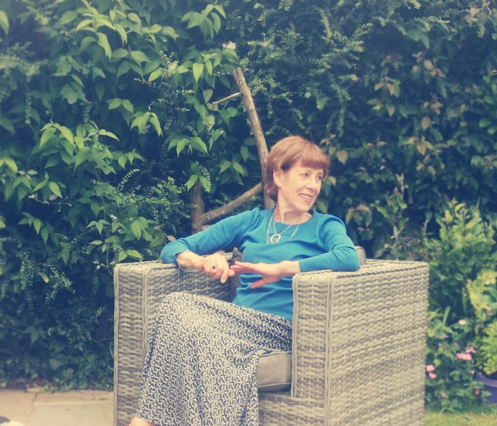 Kathleen Jackson sits in a chair outside.