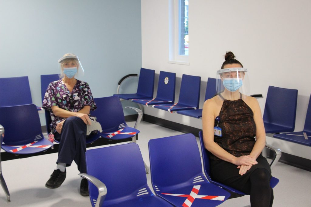 Two staff members sit in the waiting room.