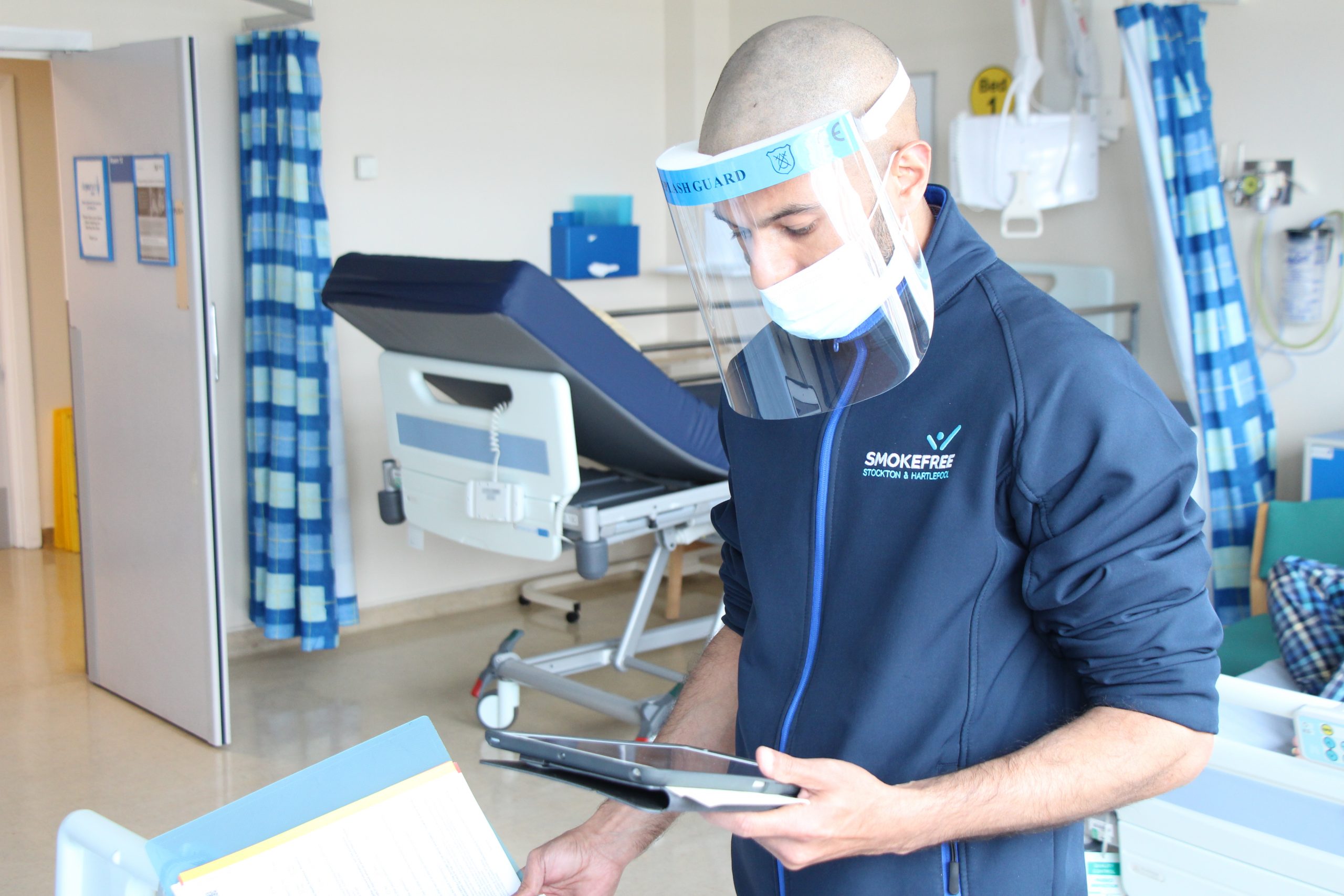 A hospital staff member holds a tablet.