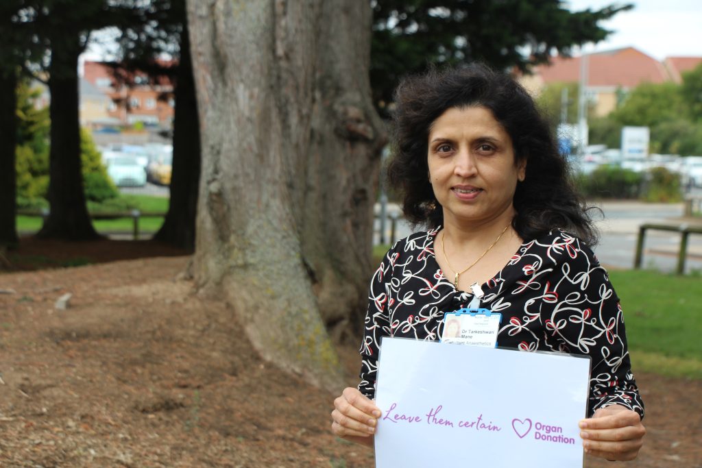 Tara Mane holds a sign which reads: "Leave them certain".
