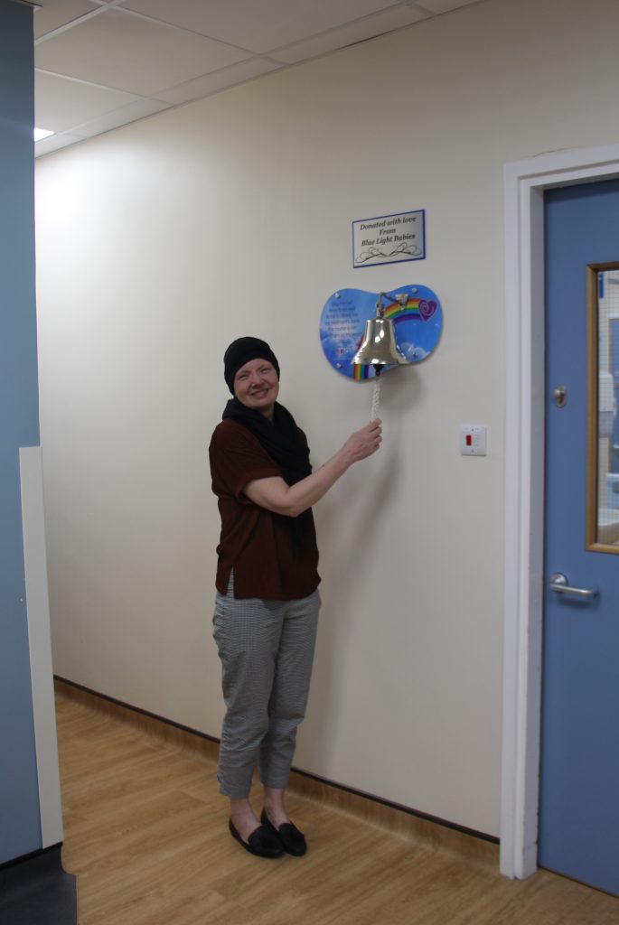 Amanda Rees ringing the bell on the unit to mark the end of treatment.