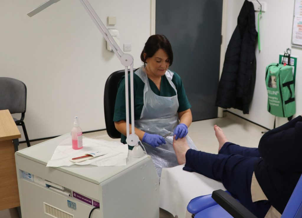 Lucy clipping a patient's toenails.