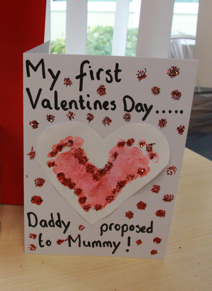Handmade card shows a love heart made from baby's footprints. Card reads "My first Valentines' Day... Daddy proposed to Mummy!"