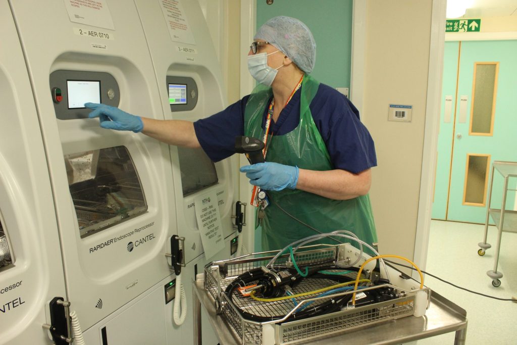 A member of the sterile services team using an endoscopy cleaning machine.