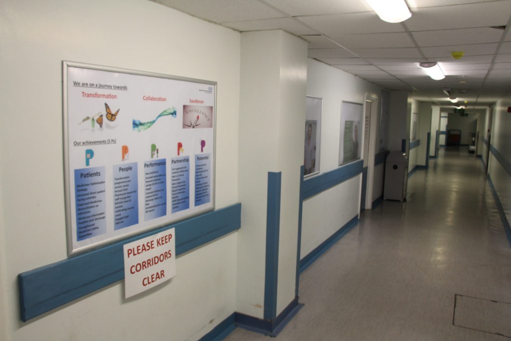 Pharmacy corridor. Posters are hung up.