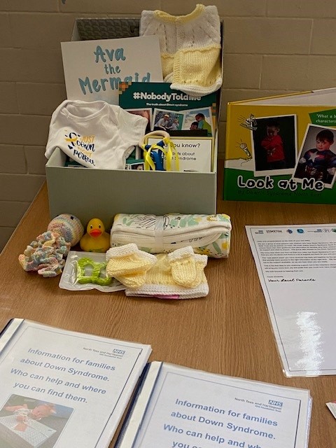 A sample of a gift box. It includes clothing, toys and information for families.