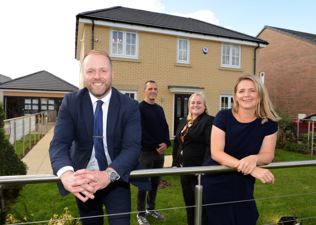 Mark Bayliss and Donna Clark from Miller Homes Teesside and Suzi Campbell and Tom Bingham from North Tees and Hartlepool NHS Foundation Trust stand outside a home.