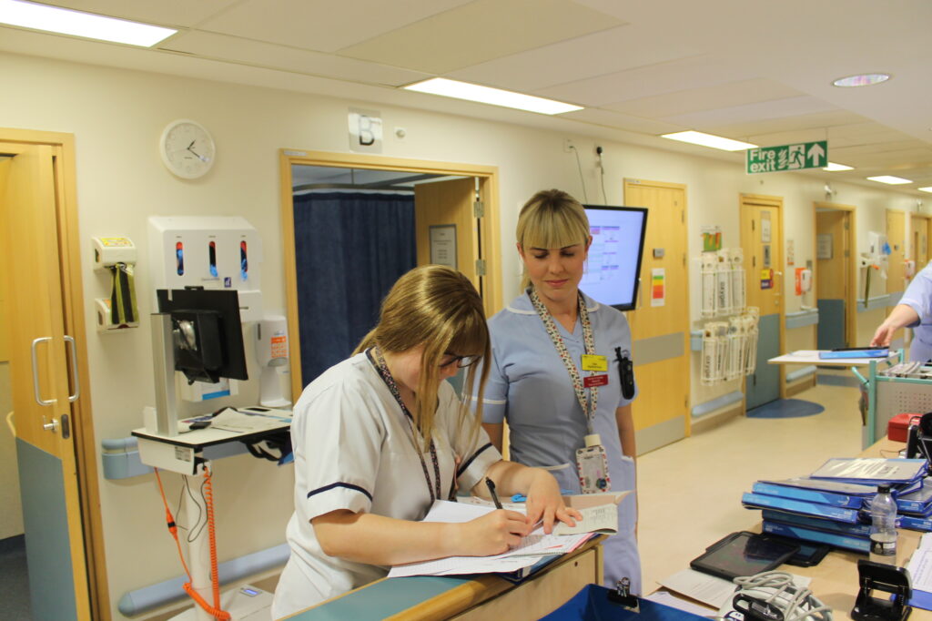Two staff talk on a ward.