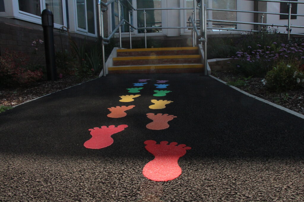 Printed footsteps on the ground lead to a small set of stairs.