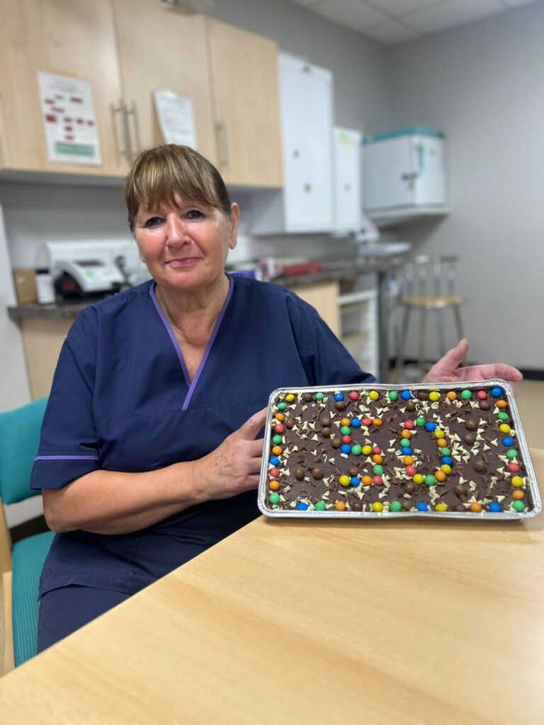 Sandra with her cake to celebrate 50 years in the NHS