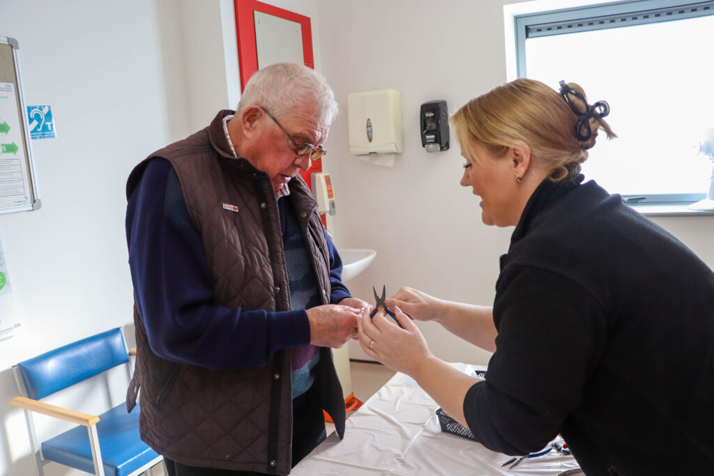 Member of the public in a retubing workshop with a member of the audiology team