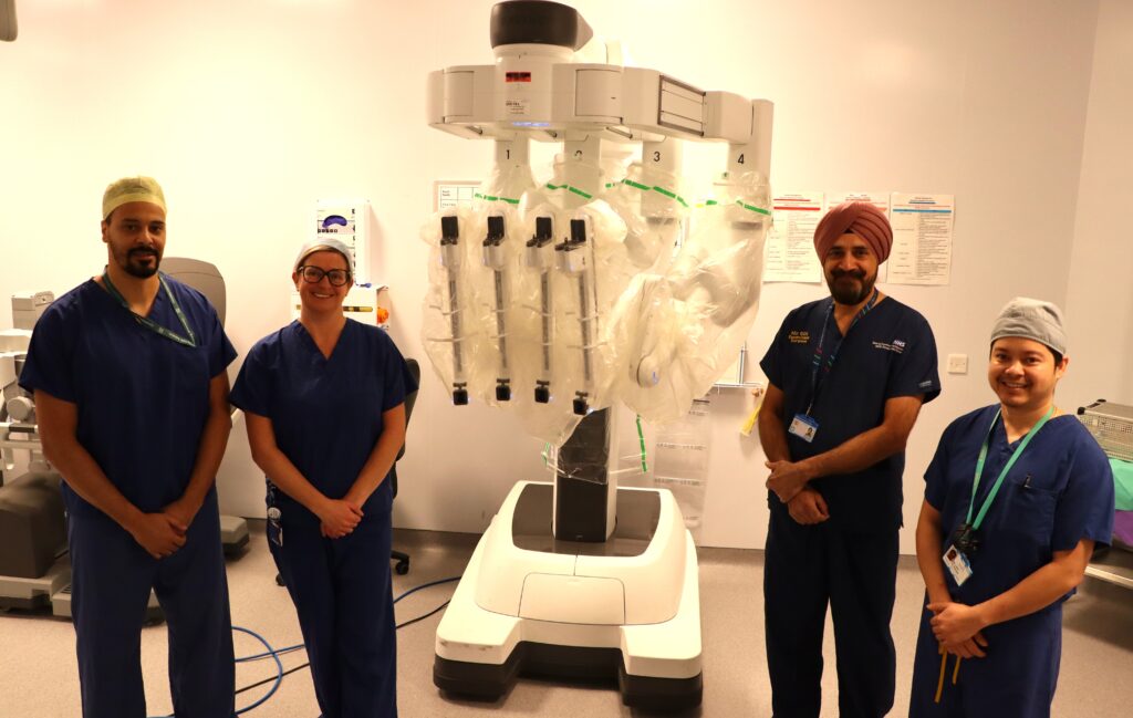 Theatre team stood in front of robot.