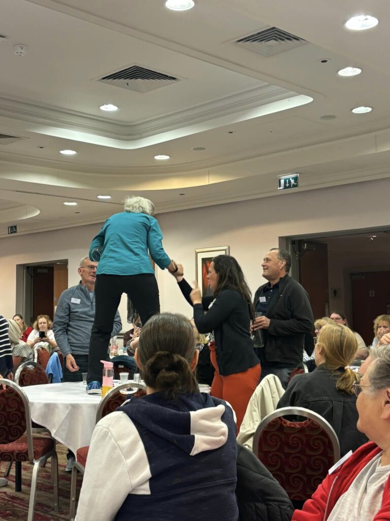 A lady stands on a table.