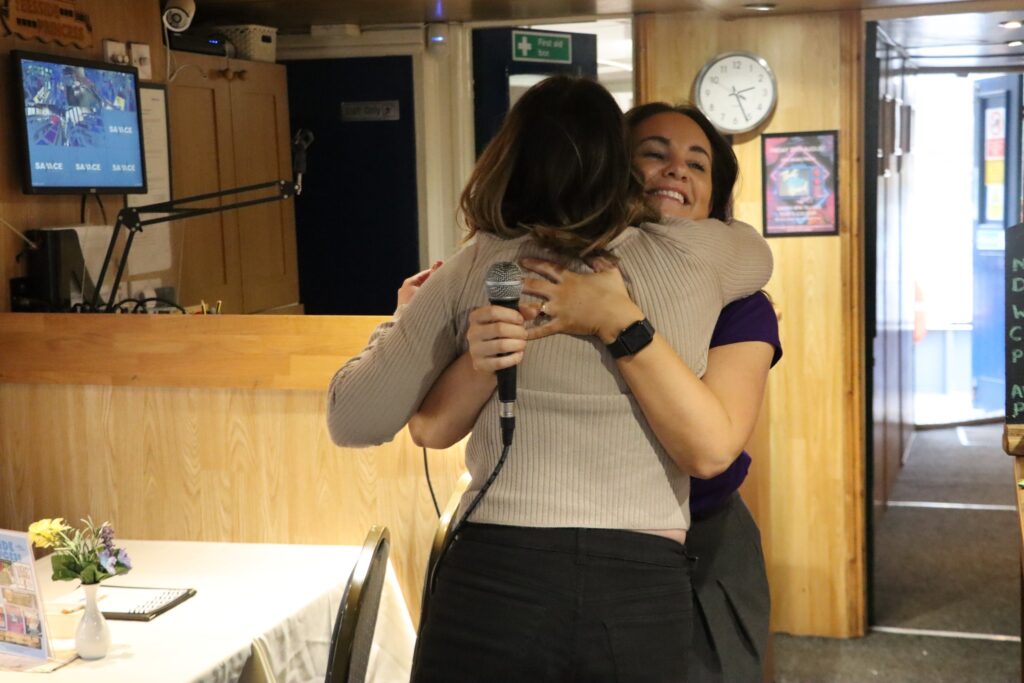 Two women hug.