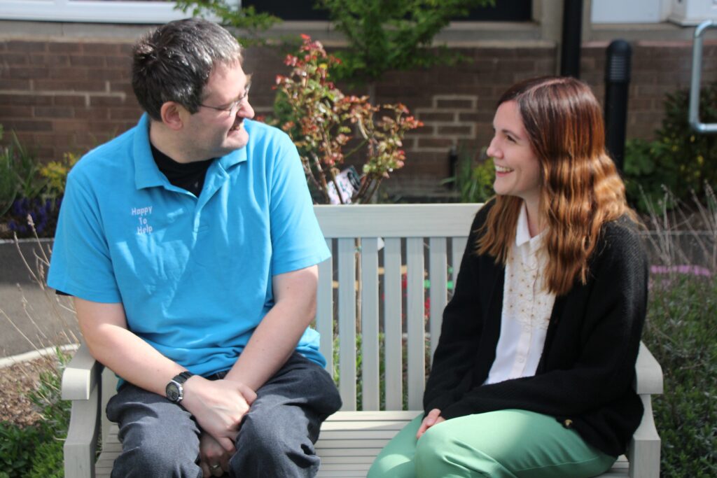 Paul Storey, volunteer, Lindsay Rutherford-Hoe, volunteer coordinator sat on a bench
