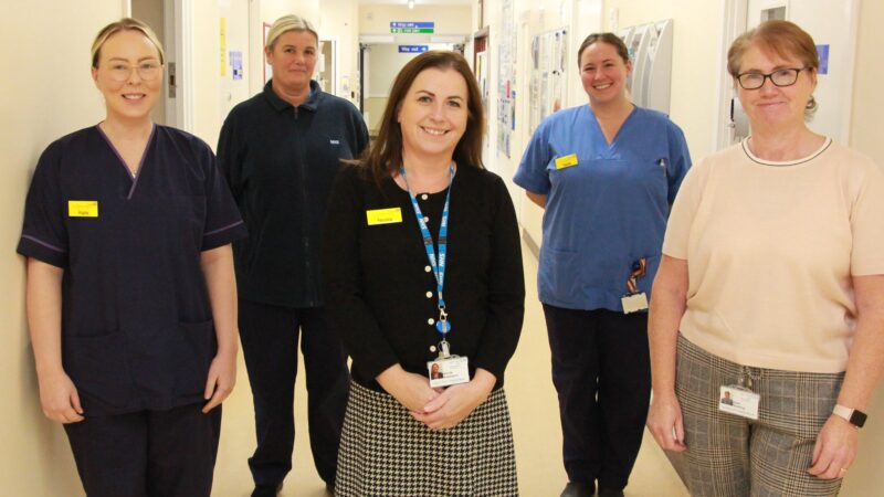 Cervical screening team stand in corridor