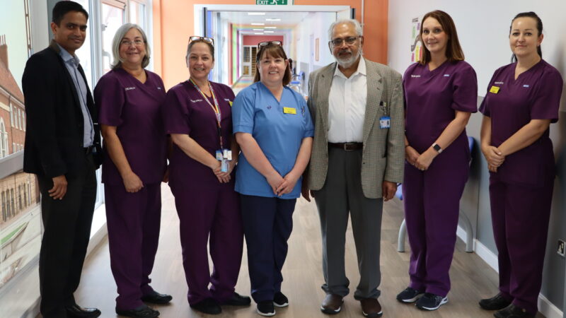 Cancer team stand in rainbow corridor