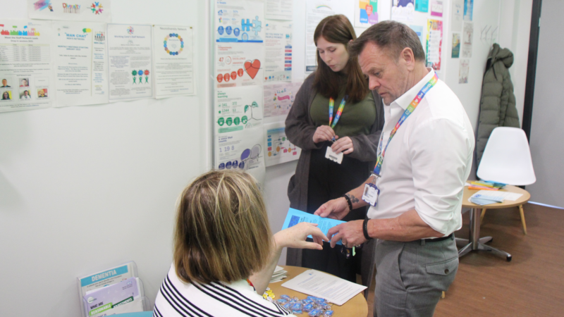 A person discusses a brochure with another.