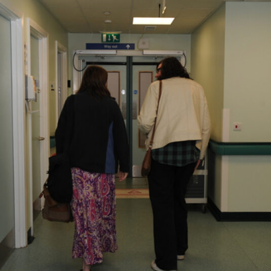 two people walking down a corridor