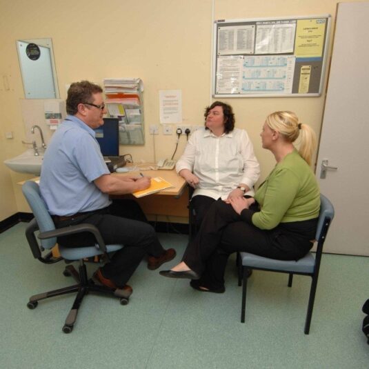 a patient and carer discuss test results with a GP