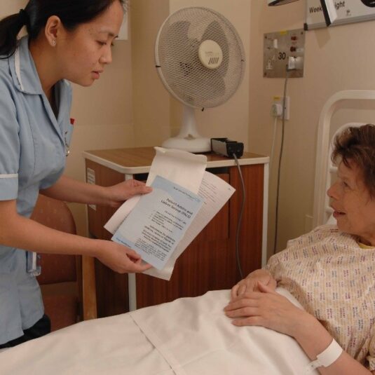 Patient is shown discharge letter and information in ward bed