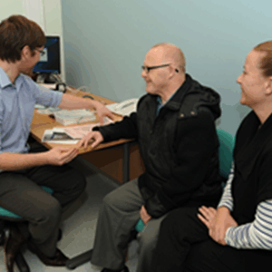 Patient talking to his GP with a carer.