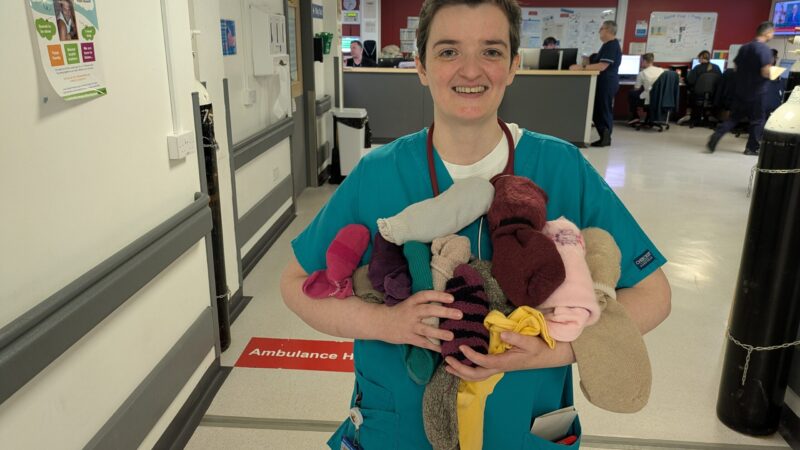 Doctor in emergency care holding pairs of socks.