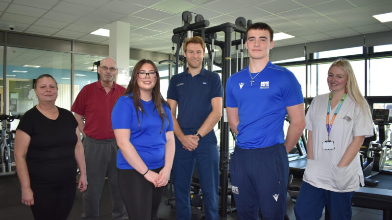 Hospital staff and students stand in a gym.