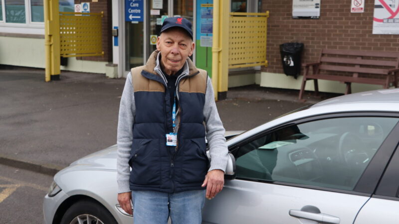 Hospital volunteer driver stood by his car