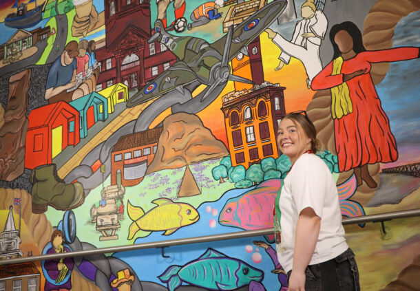 Lily Rose Cockfield with the main mural at the Tees Valley Community Diagnostic Centre