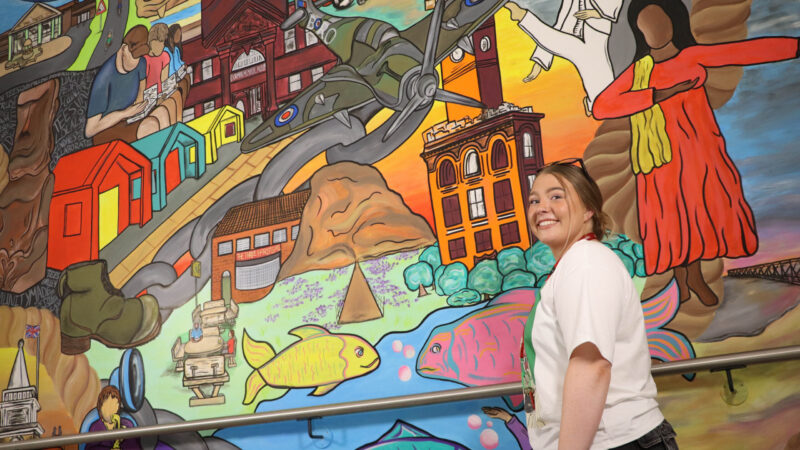 Lily Rose Cockfield with the main mural at the Tees Valley Community Diagnostic Centre