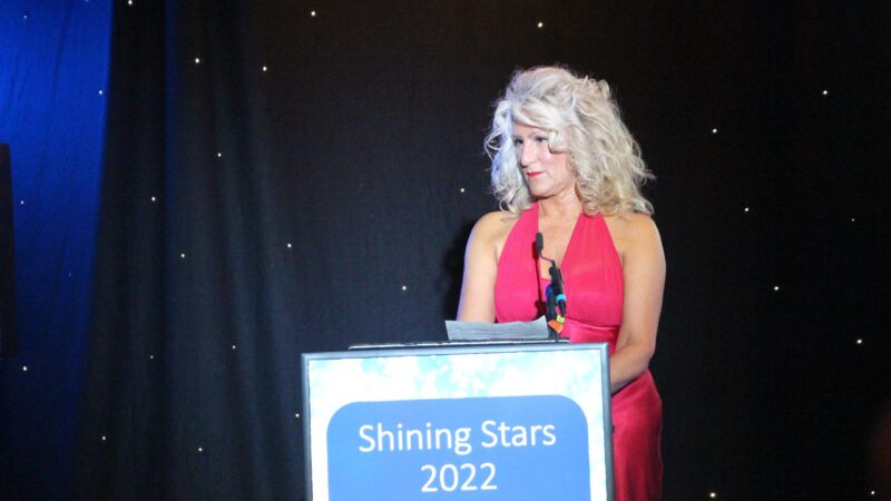 Julie Gillon speaking at a podium at the event.