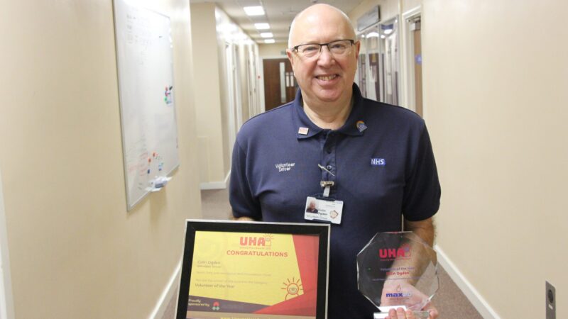 Colin Ogden holds his certificate and award.