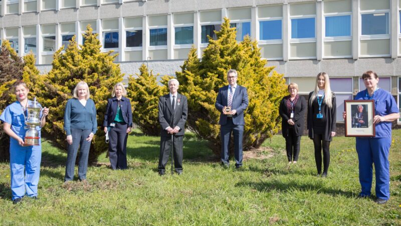 Eric and members of staff stand outside the University Hospital of North Tees.