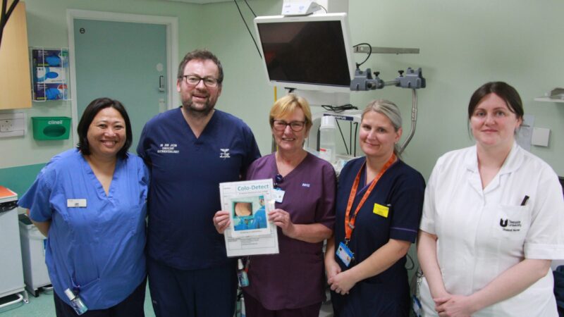 The study team. One holds an information leaflet about Colo-Detect.