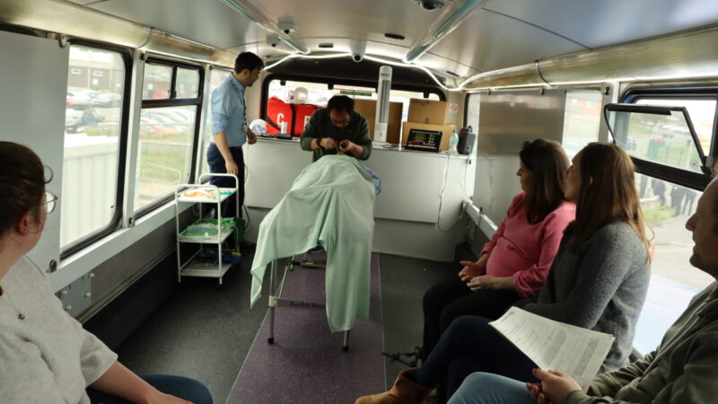 Medical students watch a high acuity, low occurrence procedure on the NHS Melissa Bus