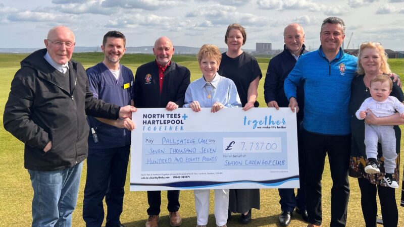 Members of the golf club and the Trust's palliative care team. They hold a giant cheque.