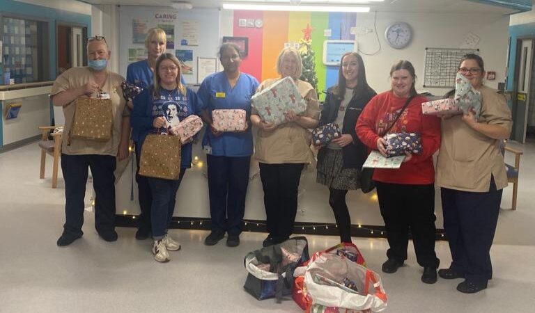 Ward staff and Miller Homes staff hold gifts.