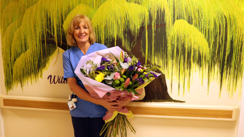 Midwife Janice Haswell holding a huge bouquet of flowers on her last day before retirement.