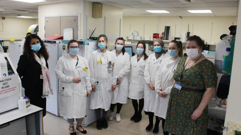 Female scientists wearing white coats. They are in a pathology lab.