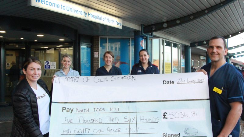 Kirsty Wass presents a giant cheque to members of the ITU team. They stand outside the University Hospital of North Tees.