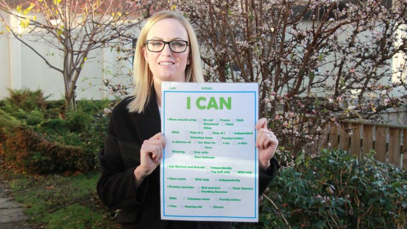Leanne Mitchell holding an 'I can' board.