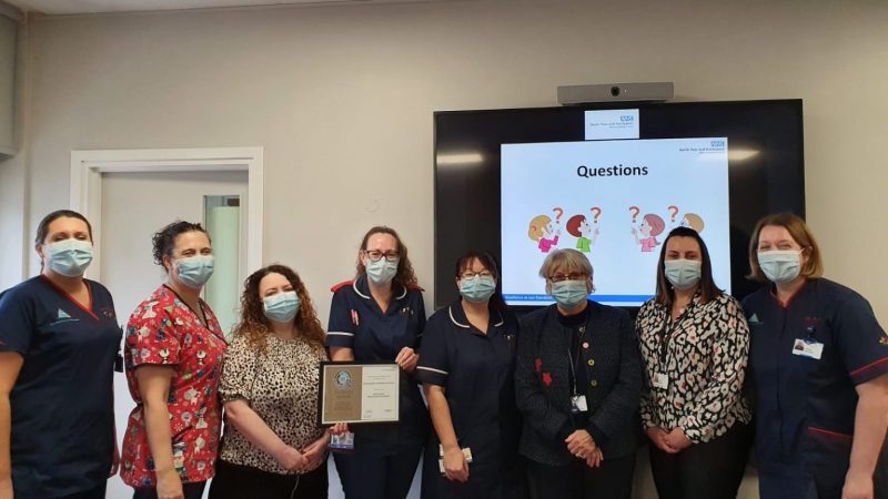Members of the children's ward with the Trust's senior leader team. Heather Walker holds a certificate.