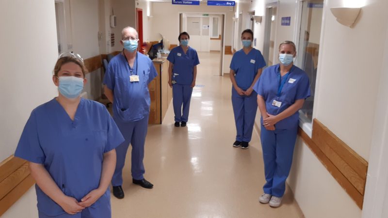 Members of the vaccine trial team stand in a hospital corridor.