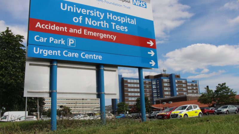 Signpost for the University Hospital of North Tees. It shows arrows directing to 'Accident and Emergency', 'Car Park' and 'Urgent Care Centre'.