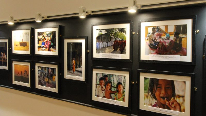 Part of the gallery display. Photos on display include families, Cambodian monks and farmers.