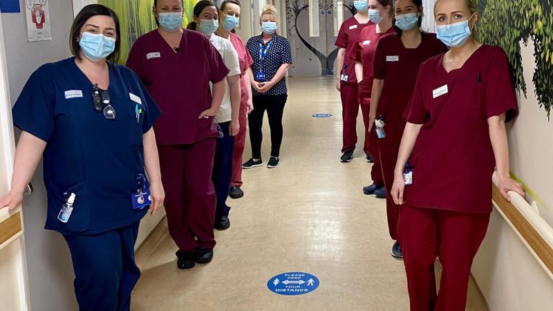Some of the maternity team stand in a corridor. They all wear face masks.