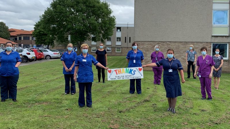 Covid research nurses hold thank you banner
