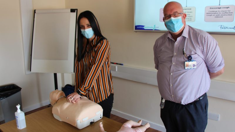 A staff member performs CPR on a manikin.